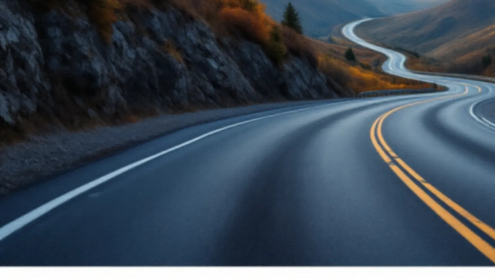 A winding mountain highway with a steel guardrail curving through autumn hills at dawn, the PistonFunds view of cash advance online, $100 – $5,000